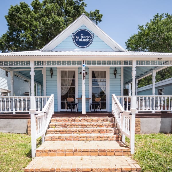 Big Boned Barbecue restaurant, a light blue house with a white porch and brick steps.